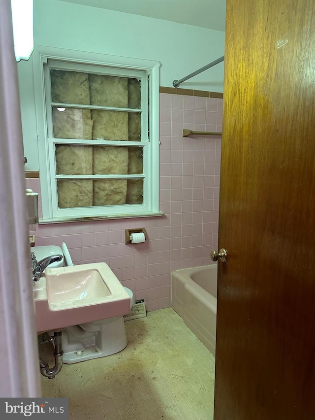 bathroom featuring sink and tile walls