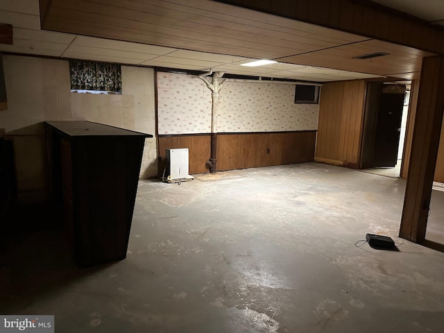 basement featuring wood walls