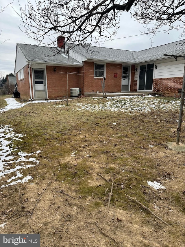 snow covered property with central AC unit