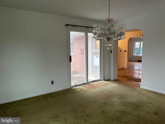 unfurnished dining area with carpet and a notable chandelier