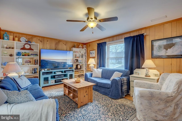 living room featuring crown molding, hardwood / wood-style floors, and wood walls