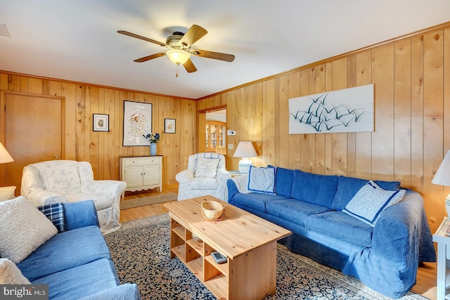 living room with crown molding, wood-type flooring, and ceiling fan