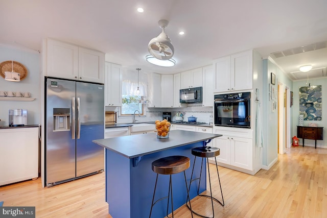 kitchen featuring white cabinetry, pendant lighting, sink, and black appliances