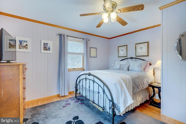 bedroom with crown molding, light hardwood / wood-style flooring, and ceiling fan