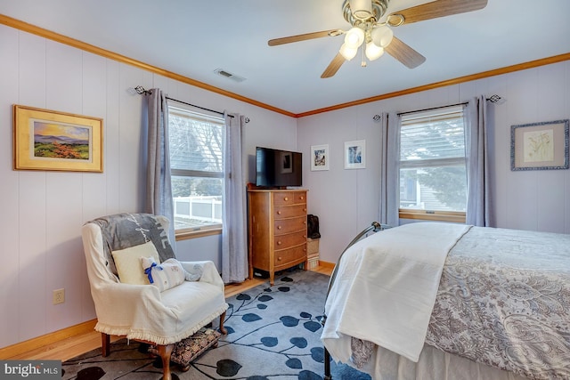 bedroom with crown molding, ceiling fan, and hardwood / wood-style flooring