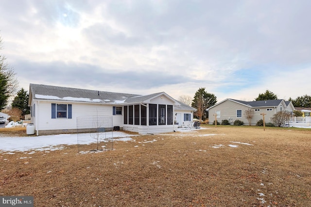 back of house with a sunroom and a lawn