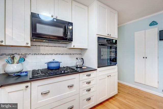 kitchen featuring ornamental molding, black appliances, and white cabinets