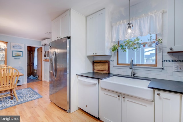 kitchen with pendant lighting, sink, stainless steel fridge, white cabinetry, and white dishwasher