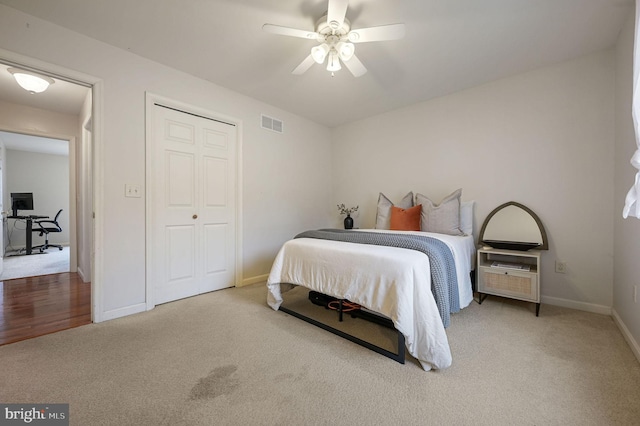 carpeted bedroom featuring ceiling fan and a closet