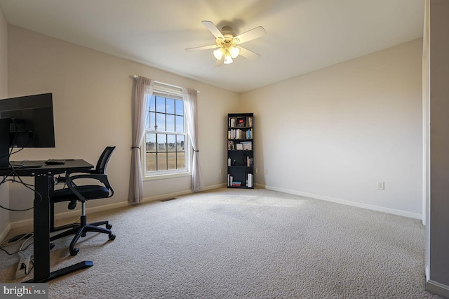 carpeted home office featuring ceiling fan