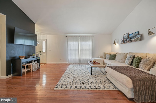 living room featuring hardwood / wood-style flooring and vaulted ceiling