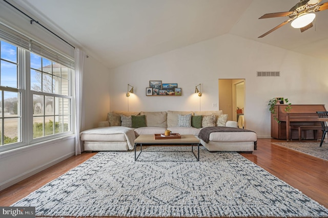 living room featuring ceiling fan, wood-type flooring, and vaulted ceiling