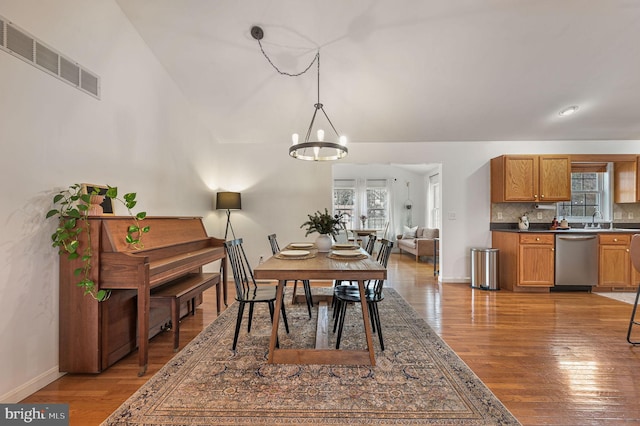 dining area featuring hardwood / wood-style flooring, sink, and an inviting chandelier