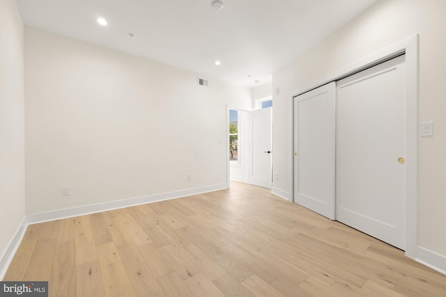 unfurnished bedroom with a closet and light hardwood / wood-style flooring