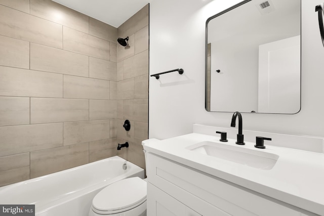 full bathroom with toilet, vanity, and tiled shower / bath