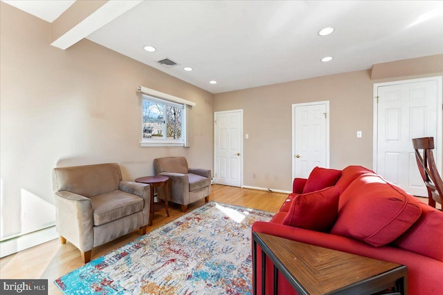 living room with a baseboard heating unit, beamed ceiling, and hardwood / wood-style flooring