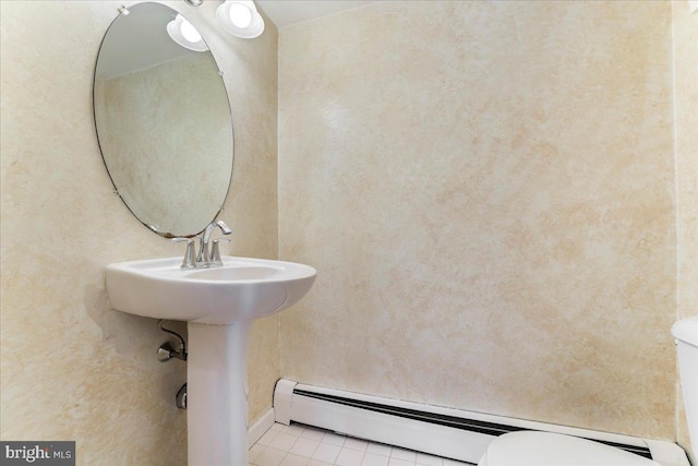 bathroom featuring toilet, tile patterned flooring, and a baseboard heating unit