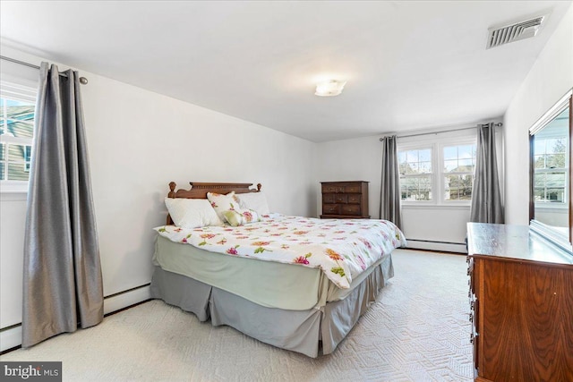 bedroom with multiple windows and a baseboard heating unit