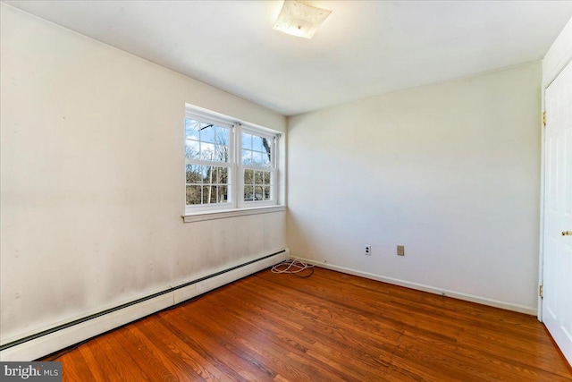 unfurnished room featuring wood-type flooring and baseboard heating