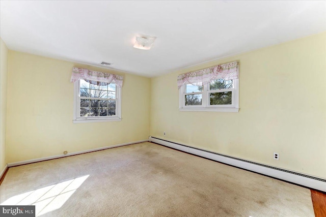 carpeted spare room with a baseboard radiator