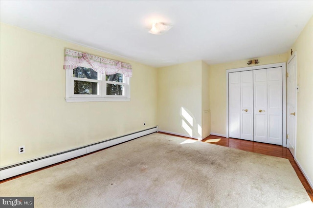 unfurnished bedroom featuring baseboard heating and a closet