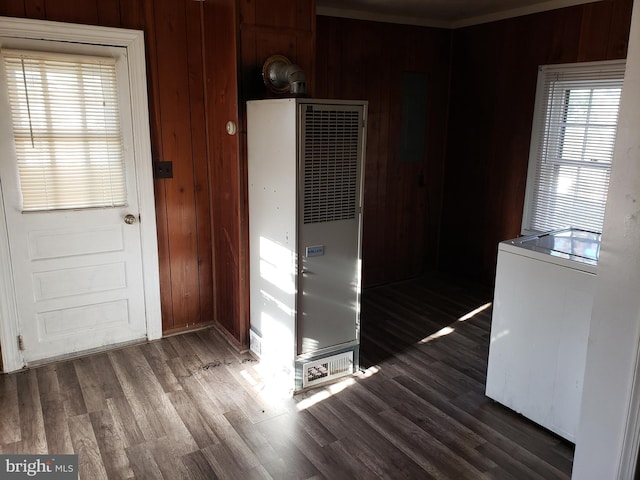 spare room featuring ornamental molding, dark hardwood / wood-style flooring, and wood walls