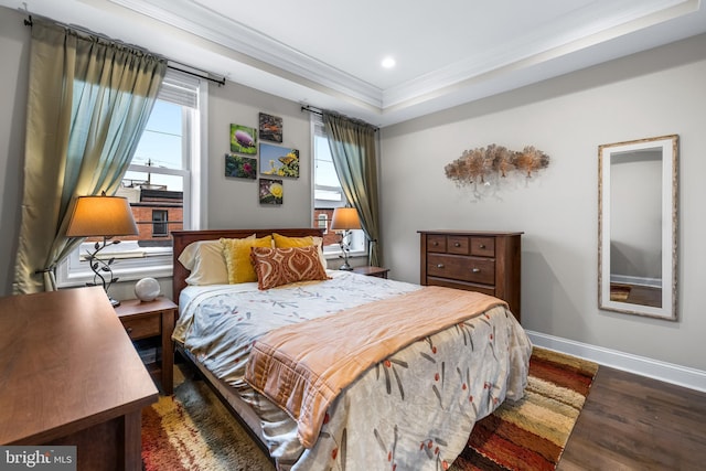 bedroom featuring dark hardwood / wood-style floors, a raised ceiling, and ornamental molding