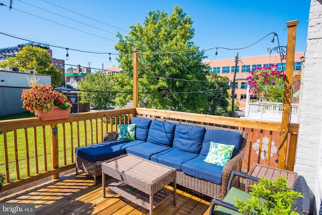 wooden terrace with an outdoor living space and a yard