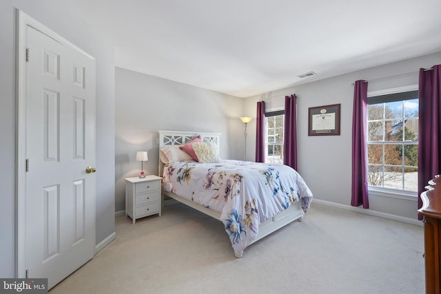 bedroom featuring light colored carpet and multiple windows