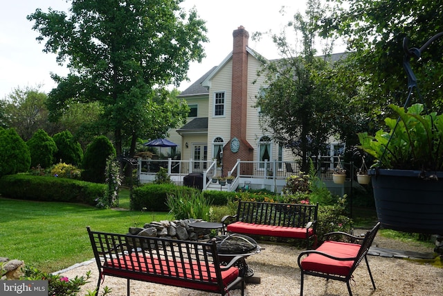 back of property with a patio, a yard, and a fire pit