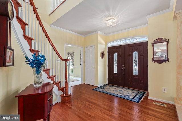 entrance foyer featuring hardwood / wood-style floors, crown molding, and an inviting chandelier