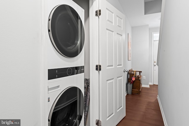 washroom with laundry area, baseboards, stacked washer / drying machine, and dark wood-type flooring