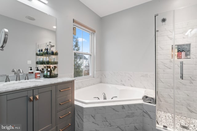 bathroom featuring vanity, a garden tub, and a shower stall