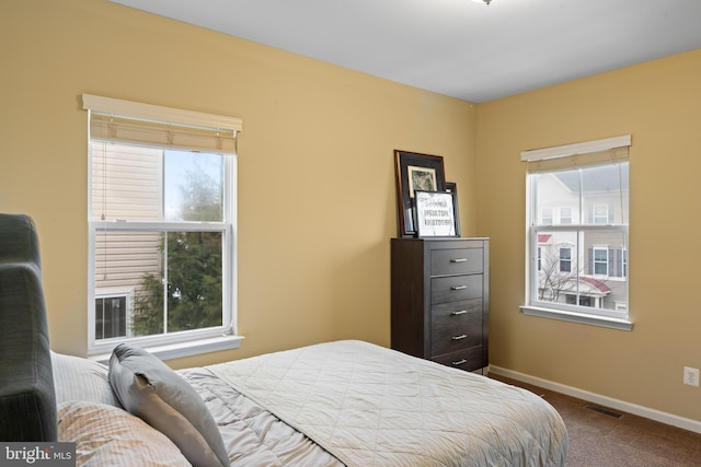 bedroom with visible vents, baseboards, and dark carpet