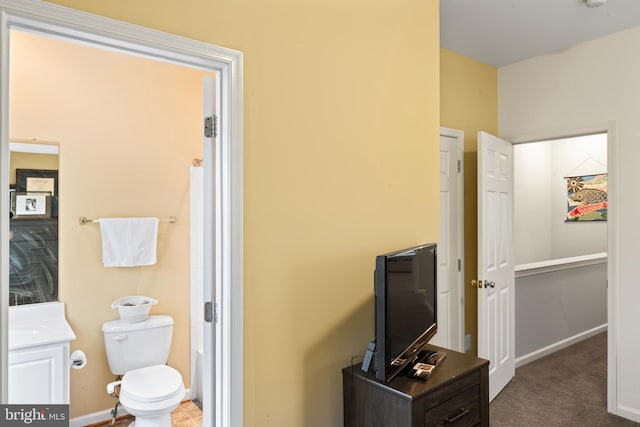 bathroom with baseboards, toilet, and vanity