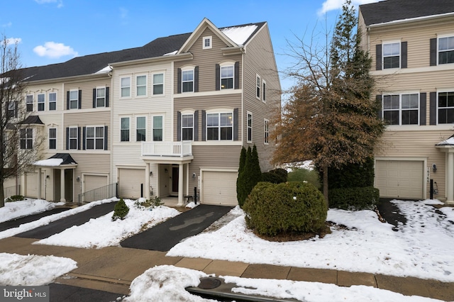 multi unit property featuring aphalt driveway and an attached garage