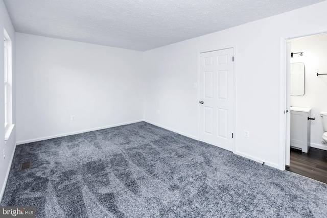 carpeted spare room featuring a textured ceiling