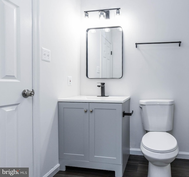 bathroom featuring toilet, vanity, and wood-type flooring