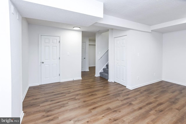 basement featuring dark wood-type flooring and a textured ceiling