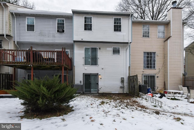 snow covered property with a wooden deck and central air condition unit