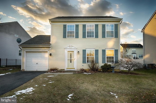 view of front of home featuring central AC unit, a garage, and a lawn