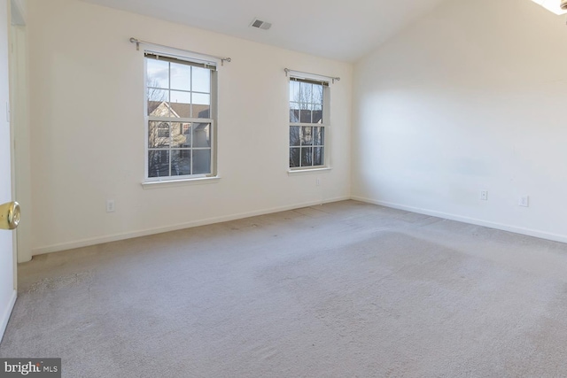 spare room with light colored carpet and lofted ceiling