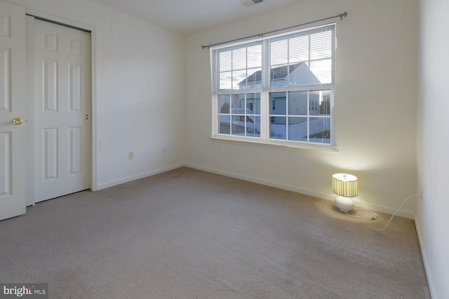 spare room featuring light carpet