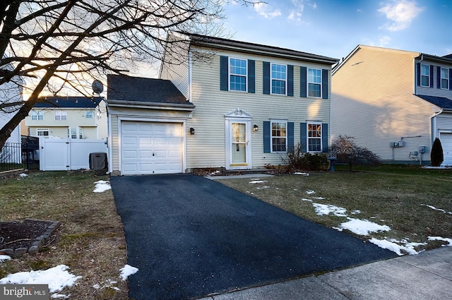 view of front of property with a front yard, central AC unit, and a garage