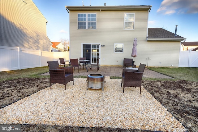 rear view of property with a patio and an outdoor fire pit