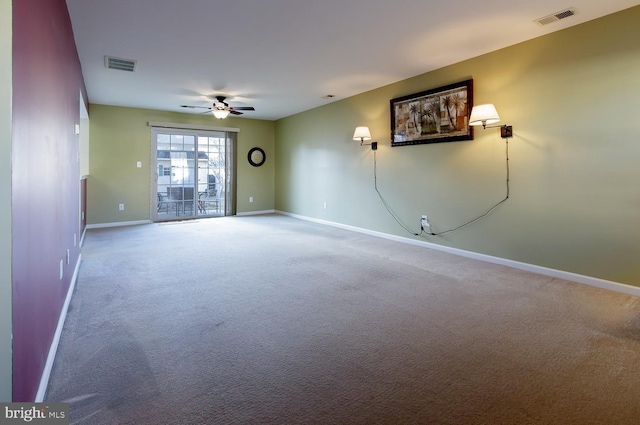 empty room featuring ceiling fan and carpet