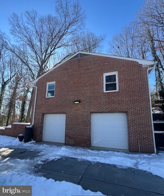 view of snow covered exterior with a garage