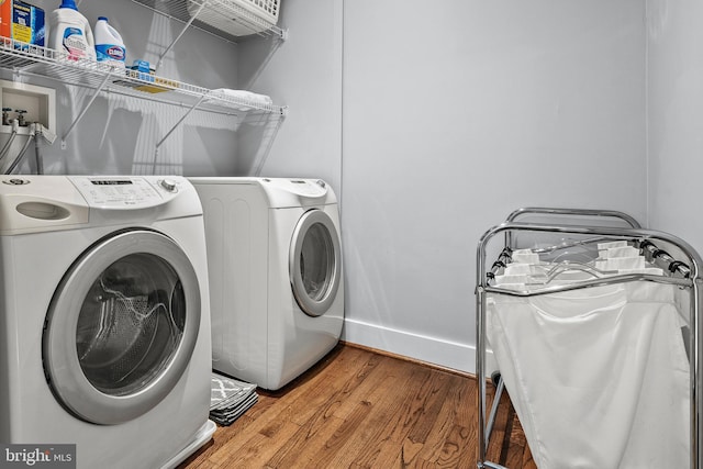 laundry room with wood-type flooring and washer and dryer