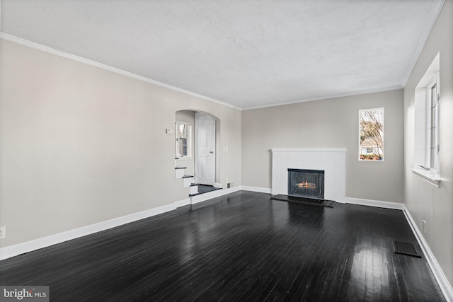 unfurnished living room with wood-type flooring, a brick fireplace, and ornamental molding