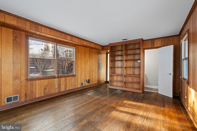 interior space featuring dark wood-type flooring, built in shelves, and wood walls